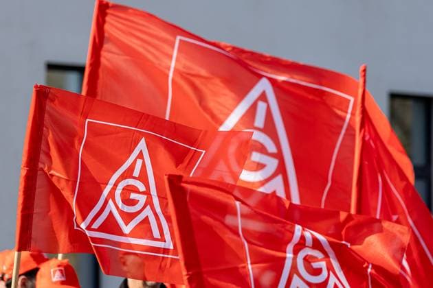 IG Metall Warnstreiks im bayerischen Kfz-Handwerk, Nürnberg, 02.04.2025 Mehrere rote Fahnen mit dem Logo der IG Metall sind während einer gewerkschaftlichen Kundgebung zu sehen. Im Hintergrund tragen Personen rote Kappen mit dem Emblem der Gewerkschaft. Der Fokus liegt auf den wehenden Fahnen im Vordergrund. Nürnberg Bayern Deutschland