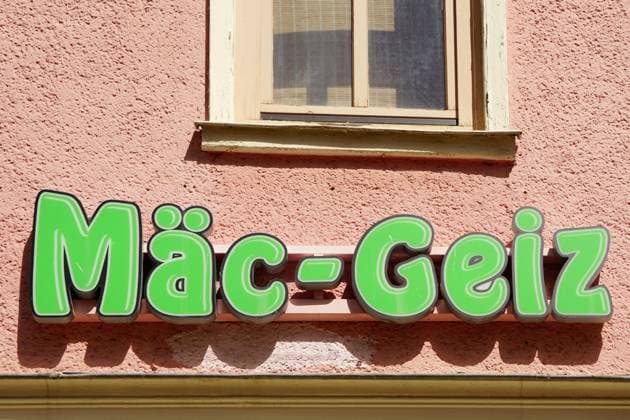 Mäc-Geiz, Firmenlogo, Leuchtreklame an einer Hauswand, deutscher Non-Food-Discounter