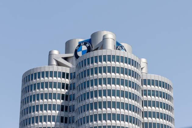 München, Deutschland - 14. Juni 2025: Nahaufnahme des Gebäudes der BMW-Zentrale in München mit seinem einzigartigen Vierzylinder-Design und dem BMW-Logo vor einem klaren blauen Himmel.