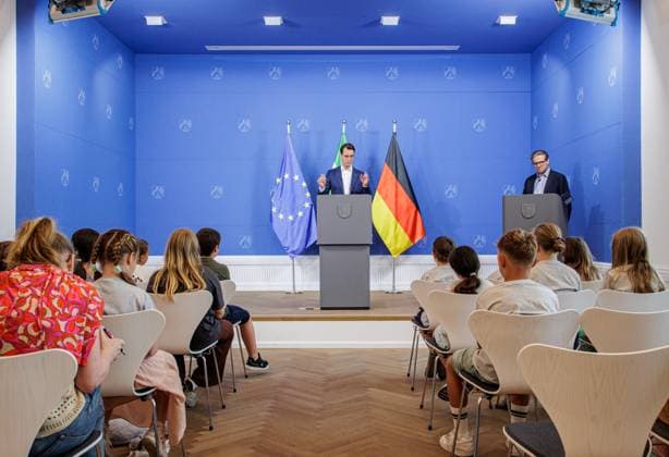 05.07.2025. Düsseldorf. Was macht eine Staatskanzlei? Wie funktioniert Demokratie? Wie arbeitet ein Ministerpräsident? Fragen wie diese – und viele weitere – stellen Schülerinnen und Schüler aus zwei Grundschulen (GGS Engelskirchen-Ründeroth und GGS Marktschule Bonn-Pützchen) Nordrhein-Westfalens Ministerpräsident Hendrik Wüst während einer Kinderpressekonferenz im Rahmen des Tags der offenen Tür im Regierungsviertel. Hier: Christian Wiermer, Regierungssprecher des Landes Nordrhein-Westfalen und Staatssekretär für Europaangelegenheiten sowie Internationales. Düsseldorf Staatskanzlei Nordrhein-Westfalen Deutschland