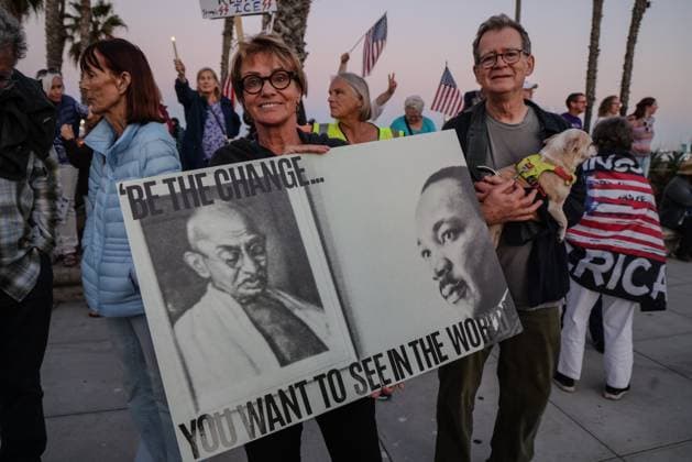 July 17, 2025, Santa Barbara, Ca, USA: A Protesting woman holds a sign that says, Ã¢â‚¬oeBe the Change You want to see in the worldÃ¢â‚¬Â? with photos of Gandhi and Martin Luther King Jr. on the poster. Next to her a man holds a little dog. They joined over a thousand people gathered for the Good Trouble protest at Stearns Wharf and State St., stretching out along Cabrillo Blvd. in Santa Barbara California on July 17, 2025, calling for ICE out of Santa Barbara, impeachment of President Trump, and other issues. Santa Barbara USA - ZUMAk144 20250717_znp_k144_021 Copyright: xAmyxKatzx