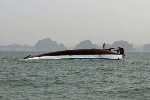 Bilder des Jahres 2025, News 07 Juli 18 dead, many missing after Vietnamese tourist boat capsizes HALONG BAY, QUANG NINH PROVINCE, VIETNAM - JULY 19: (----EDITORIAL USE ONLY - MANDATORY CREDIT - VIETNAMS S TRAFFIC POLICE DEPARTMENT HANDOUT - NO MARKETING NO ADVERTISING CAMPAIGNS - DISTRIBUTED AS A SERVICE TO CLIENTS----) Two men are seen standing on a capsized tourist boat, which was believed to be carrying more than 50 passengers on board, in Halong Bay, Quang Ninh Province, Vietnam, on July 19, 2025. At least 18 people have died and 23 are missing after a tourist cruise boat carrying 53 people capsized in Vietnam s Ha Long Bay on Saturday, according to officials. Vietnam s Traffic Police Department Handout Anadolu Quang Ninh Province Vietnam. Editorial use only. Plea Copyright: x2025xAnadoluxVietnam sxTrafficxPolicexDepartmentx xHandoutx