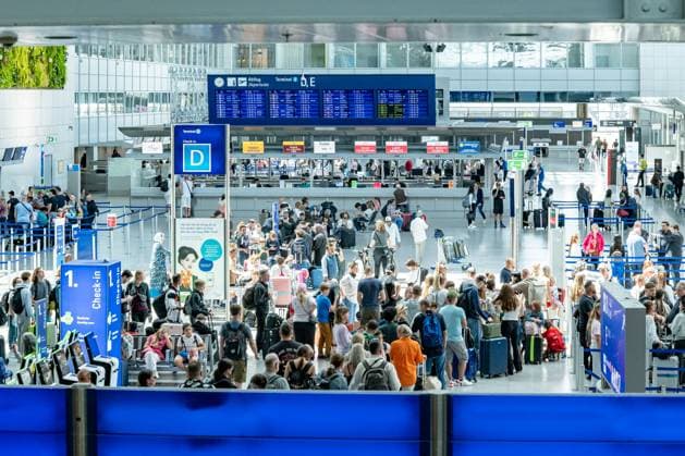 Großer Andrang am Check-in Terminal D, Flughafen Frankfurt 22.07.25, Frankfurt: Symbolfoto, Illustrationsbild, Symbolbild, Illustrationsfoto, Alltagsszene Weitwinkelaufnahme vom Check-in-Bereich im Terminal D des Frankfurter Flughafens. Hunderte Menschen warten in Schlangen an den Schaltern. Über den Köpfen ist eine große digitale Abflugtafel zu sehen, die internationale Flugverbindungen anzeigt. Die Szene dokumentiert eindrucksvoll das hohe Passagieraufkommen in Spitzenzeiten und den logistischen Ablauf im Luftverkehr. Frankfurt Hessen Deutschland Copyright: xW2Artx xThorstenxWagnerx