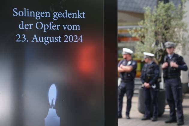 Ein Jahr nach dem terroristischen Anschlag in Solingen wird am Samstag (23.08.2025) der Opfer gedacht (Foto: Polizisten stehen neben einer digitalen Gedenktafel). Bei dem islamistisch motivierten Messeranschlag am 23. August 2024 hatte ein als Asylbewerber nach Deutschland gekommener Syrer Besucher des Solinger Stadtfestes zum 650-jaehrigen Bestehen angegriffen. Drei Menschen wurden durch Stiche getoetet und acht verletzt. Gegen den mutmasslichen Taeter Issa al H. laeuft derzeit der Prozess vor dem Oberlandesgericht Duesseldorf. Der Anschlag hatte eine intensive Debatte ueber die Asyl- und Fluechtlingspolitik ausgeloest. (Siehe epd-Meldungen vom 23.08.2025) EDITORIAL USE ONLY