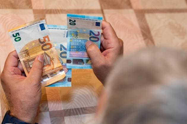 Ein alter Mann hält 50 und 20 Euro-Scheine in den Händen. Das Bild symbolisiert die finanzielle Sicherheit im Alter und steht für das Thema Rente, Altersvorsorge und den Bezug von Rentenzahlungen.