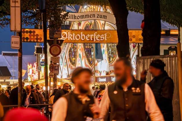Bilder des Jahres 2025, News September 09 Willkommen zum Oktoberfest, Wiesnbesucher am Haupteingang der Wiesn, am Abend, September 2025 Deutschland, München, September 2025, Oktoberfest 2025, Willkommen zum Oktoberfest, Haupteingang der Wiesn, Wiesnbesucher abends, bayerisch, Volksfest, Bayern,