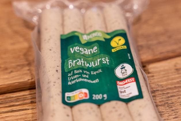 Vegane Bratwurst Produktfoto im Zusammenhang mit EU-Diskussion über Bezeichnungen pflanzlicher Fleischalternativen 12.10.25, Selters: Symbolfoto, Illustrationsbild, Symbolbild, Illustrationsfoto, Alltagsszene Nahaufnahme einer Verpackung Vegane Bratwurst der Marke Vemondo auf einer Holzoberfläche. Das Produkt besteht aus pflanzlichen Zutaten wie Rapsöl, Erbsen- und Ackerbohnenprotein. Symbolbild zur EU-Debatte über die Verwendung traditioneller Fleischbegriffe wie Bratwurst, Schnitzel oder Steak für vegane und vegetarische Lebensmittel. Das Bild thematisiert Nachhaltigkeit, Konsumverhalten und die Entwicklung pflanzlicher Alternativen im europäischen Lebensmittelmarkt. Selters Hessen Deutschland Copyright: xThorstenxWagnerx