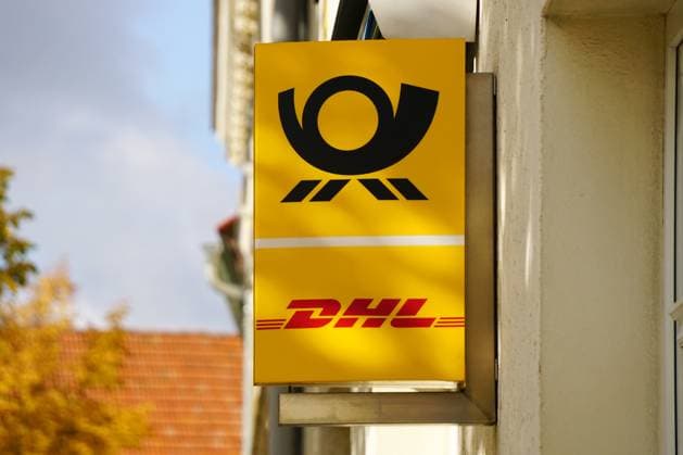 Paketannahme, DHL Reklameschild mit Postsymbol am Eingang einer Postfiliale