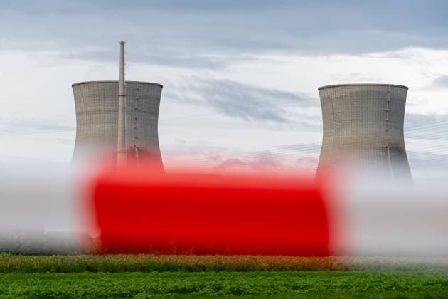 Das Atomkraftwerk am Tag der Sprengung der Kühltürme des stillgelegten Kernkraftwerks Gundremmingen (AKW KRB) in Bayern. Die beiden 160 Meter hohen Türme werden am Samstag, 25. Oktober 2025, um 12 Uhr gesprengt. Symbolfoto Atomausstieg, Absperrband bzw Warnbake im Vordergrund, im Hintergrund das AKW