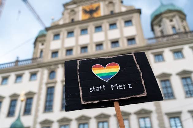 Hunderte Menschen demonstrieren in Augsburg: Teilnehmer protestieren gegen die Stadtbild-Aussage (Problem im Stadtbild) von Bundeskanzler Friedrich Merz. Motto: Wir sind die Töchter, Wir sind das Stadtbild, Wir sind viele. Schild vor dem Augsburger Rathaus: Vielfalt bzw. Herz statt Merz