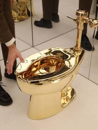 November 7, 2025, New York, New York, USA: A man examines Maurizio CattelanÃ¢â‚¬â ¢s America (2016): a fully functional toilet made from just over 100 kilograms of solid 18-karat gold, estimate starting at $10 million, seen on display during November Marquee Week 2025 during SothebyÃ¢â‚¬â ¢s Opening of the New Global Headquarters at the Breuer. New York USA - ZUMAk03_ 20251107_zaf_k03_010 Copyright: xNancyxKaszermanx