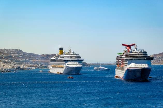 Mykonos, Kykladen, Griechenland - Kreuzfahrtschiffe CARNIVAL MIRACLE und COSTA FORTUNA liegen in der Bucht vor Mykonos-Stadt. Altstadt mit den Windmühlen. Tenderboote bringen die Touristen ans Ufer. Mykonos Mykonos Griechenland