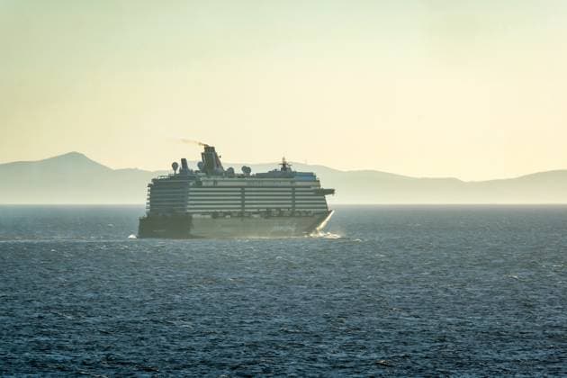 Mykonos, Kykladen, Griechenland - Kreuzfahrtschiff MEIN SCHIFF 5 faehrt aus der Hafenbucht Mykonos und hinterlaesst eine dunkle Abgaswolke. Mykonos Mykonos Griechenland