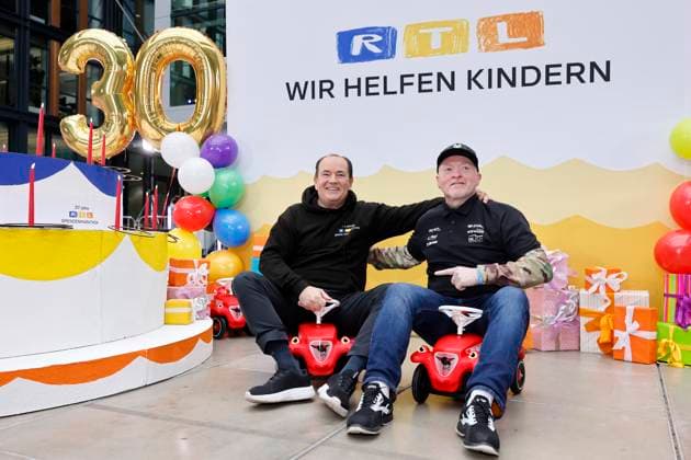 Moderator Wolfram Kons und Sänger Joey Kelly auf Rutscheautos bei einem Fototermin zu 30 Jahre RTL-Spendenmarathon im RTL-Gebäude am Picassoplatz. Köln, 19.11.2025 NRW Deutschland Copyright: xChristophxHardtx