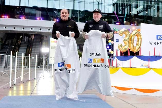 Moderator Wolfram Kons und Sänger Joey Kelly beim Sackhüpfen bei einem Fototermin zu 30 Jahre RTL-Spendenmarathon im RTL-Gebäude am Picassoplatz. Köln, 19.11.2025 NRW Deutschland Copyright: xChristophxHardtx