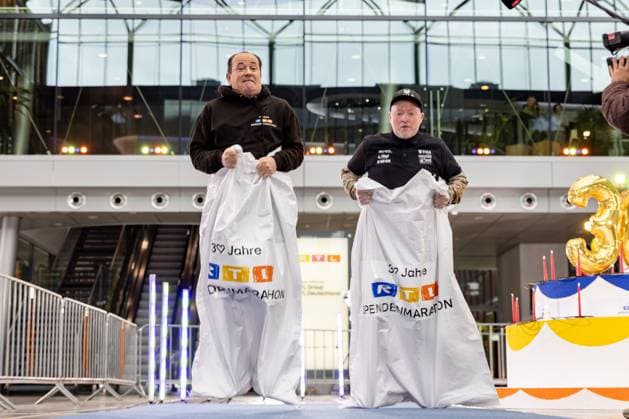 Pressetermin zum RTL Spendenmarathon in Köln, 19.11.2025. Wolfram KONS und Joey KELLY beim Sacküpfen (oder Hüpfsacken laut Kelly) - In der RTL-Zentrale in Köln-Deutz präsentieren Joey Kelly und Wolfram Kons die 24H GEBURTSTAGS-CHALLENGE zum 30. RTL-SPENDENMARATHON. Die 24-Stunden-Aktion mit 20 Firmenteams unterstützt die STIFTUNG RTL WIR HELFEN KINDERN E. V. und begleitet den Jubiläums-Spendenmarathon, der seit 1996 mehr als 306 Millionen Euro für Kinderhilfsprojekte gesammelt hat. Köln Deutz Nordrhein-Westfalen Deutschland Copyright: xBonn.digitalx