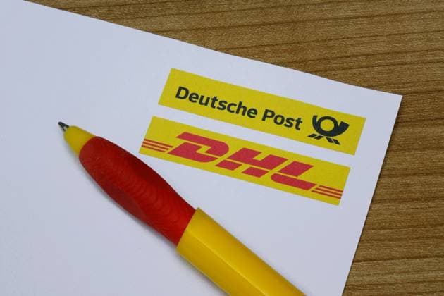 Briefbogen mit Deutsche Post und DHL sowie Kugelschreiber Briefbogen mit Deutsche Post und DHL sowie Kugelschreiber, 16.11.2025, Borkwalde, Brandenburg, Auf einem Briefbogen befinden sich die Logos der Deutschen Post und von DHL und liegt ein Kugelschreiber.