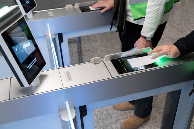 Probebetrieb für den neuen Flugsteig im Terminal 1 des Flughafens München. Freiwillige testen Abläufe vor der geplanten Eröffnung 2026. Reisende halten ihre gedruckten Bordkarten am Self-Boarding-Gate zum elektronischen Scan bereit