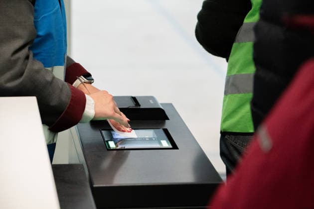 Eine Mitarbeiterin scannt am Schalter im Flughafen München eine Bordkarte, während Bodenpersonal den Boarding-Vorgang vorbereitet. Probebetrieb für den neuen Flugsteig im Terminal 1 des Flughafens München. Freiwillige testen Abläufe vor der geplanten Eröffnung 2026