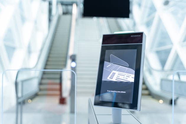 Ein automatischer Gatescanner im Flughafen München zeigt die Aufforderung zum Scannen der Bordkarte