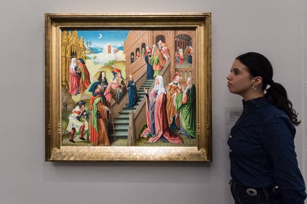 November 28, 2025, London, England, United Kingdom: A staff member looks at a painting titled The Presentation of the Virgin by Northern French School, early 16th century, estimate: 150,000 - 250,000 GBP during a photocall at Sotheby s auction house ahead of Old Master & 19th Century Paintings Sales. London United Kingdom - ZUMAs371 20251128_zip_s371_012 Copyright: xWiktorxSzymanowiczx