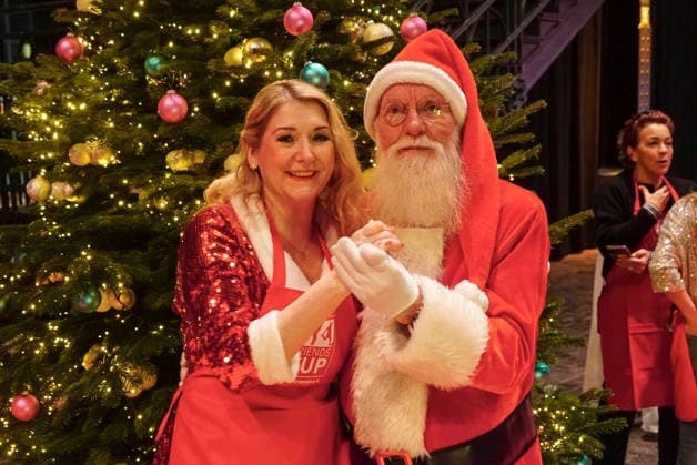 CNTVhamburg: Sandra Quadflieg Schauspielerin mit dem Weihnachtsmann John Langley NDR Gaertner als Promi Helfer bei der Weihnachtsfeier fuer Obdachlose Menschen unter dem Motto Mehr als eine warme Mahlzeit in der Fischauktionshalle am 02.12.2025 in Hamburg Hamburg Deutschland