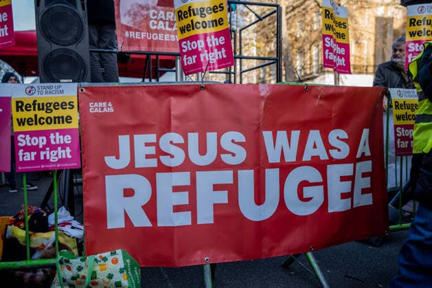 December 13, 2025, London, United Kingdom: A large banner declares that Jesus was a refugee, at an anti-racist counter demonstration to Tommy Robinson s Christian Carol Celebration. Tommy Robinson™s Unite The Kingdom movement held a large outdoor carol service in Whitehall with the aim of putting Christ back into Christmas. A large anti-racist counter demonstration was held in protest further down Whitehall at the same time, The two events were both held on Whitehall, separated by a Police cordon to prevent the two opposing groups from mixing. London United Kingdom - ZUMAs197 20251213_aaa_s197_360 Copyright: xLabxMox