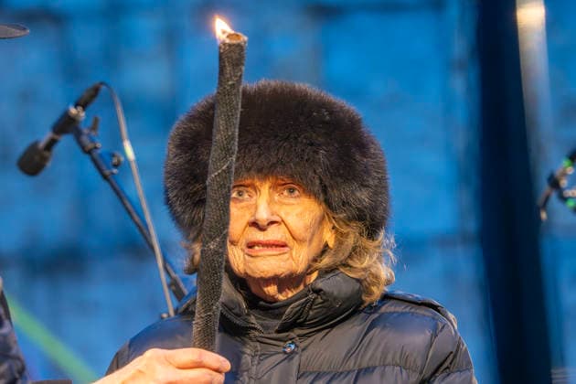 Charlotte Knobloch, 93, mit dem Chanukka-Licht, Entzünden der Chanukka-Lichter vor der Synagoge am Jakobsplatz, München, 15. Dezember 2025 Deutschland, München 15. Dezember 2025, Charlotte Knobloch, 93, Präsidentin der Israelitischen Kultusgemeinde München und Oberbayern, mit dem Chanukka-Licht, mit dieser Fackel werden danach die ersten Lichter am Chanukka-Leuchter vor der jüdischen Synagoge entzündet, Feierlichkeiten zum traditionellen Chanukka-Fest, jüdisches Lichterfest, Jakobslatz, Tradition, Bayern,