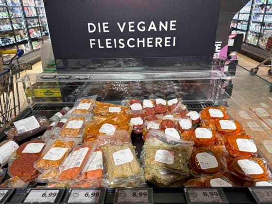 abb: Kuehlregal mit verschiedenen Sorten Wurst Steak Bratlinge Veganes Fleischprodukte Hinweisschild Aufschrift Die Vegane Fleischerei im Supermarkt bei Edeka -Vegetarisches Fleisch, Fleischersatz sind Produkte, die tierisches Fleisch ersetzen und auf Basis pflanzlicher Proteine wie Soja (Tofu, Sojagranulat), Weizen (Seitan) oder Erbsen hergestellt werden Hh Deutschland