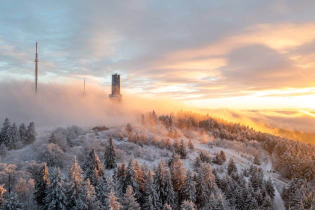Winterabend im Taunus Der Gipfel des Großen Feldbergs im Taunus ragt bei Sonnenuntergang aus dem Hochnebel., Schmitten Hessen Deutschland