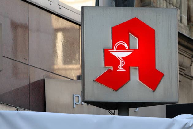 Arzneimittel aus der Apotheke An der Fassade eines Gebäudes befindet sich ein Logo einer Apotheke