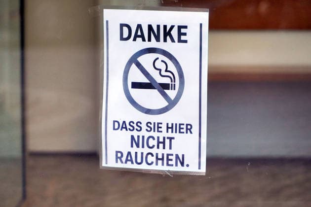 Rauchverbot in einem Gebäude, freundlicher Hinweis auf einem Schild an der Eingangstür