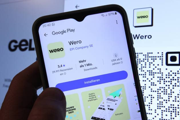 Auf einem Smartphone wurde die App vom Zahlungsdienst Wero bei Google Play aufgerufen worden. Dahinter wurde auf einem Laptop die Website von Wero aufgerufen. Symbolbild Symbolfoto. Schnelsen Hamburg