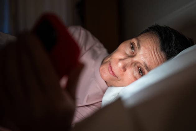 Schläfrige ältere Frau, die spät in der Nacht auf ihrem Smartphone durch soziale Medien scrollt. Sleepy senior woman phone addict scrolling social media online on smartphone, lady lying in bed in darkness looking at bright phone screen, unhealthy habit leading to eyesight problems and insomnia. (License=RF) ,model released, Symbolfoto Copyright: xZoonar.com DmitriixMarchenkox 24758782 ,model released, Symbolfoto ,property released