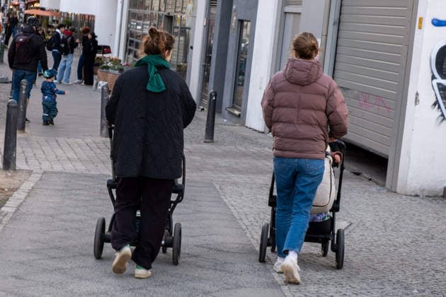 Zwei Frauen mit Kinderwagen unterwegs in Berlin-Prenzlauer Berg. Two women pushing strollers in Berlin s Prenzlauer Berg neighborhood. Zwei Frauen mit Kinderwagen
