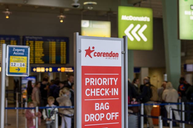 Pressekonferenz zur Stationierung eines zweiten Corendon-Flugzeugs am Albrecht Dürer Airport, Nürnberg, 27.03.2026 Ein Schild von Corendon Airlines weist im Terminal des Flughafens Nürnberg auf den Priority Check-in und die Gepäckaufgabe hin. Im Hintergrund sind wartende Reisende sowie Anzeigetafeln im Abflugbereich zu sehen. Nürnberg Bayern Deutschland