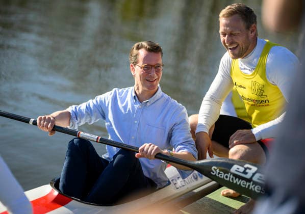 Ministerpräsident Hendrik Wüst (NRW) sitzt in einem Ruderboot und hält ein Rudern in der Hand, daneben Kanu Olympiasieger Max Rendschmidt r. Ministerpräsident Hendrik Wüst (NRW) besucht das Bundesleistungszentrum Kanusport, am 07.04.2026 in Duisburg Deutschland. Bundesleistungszentrum Kanusport