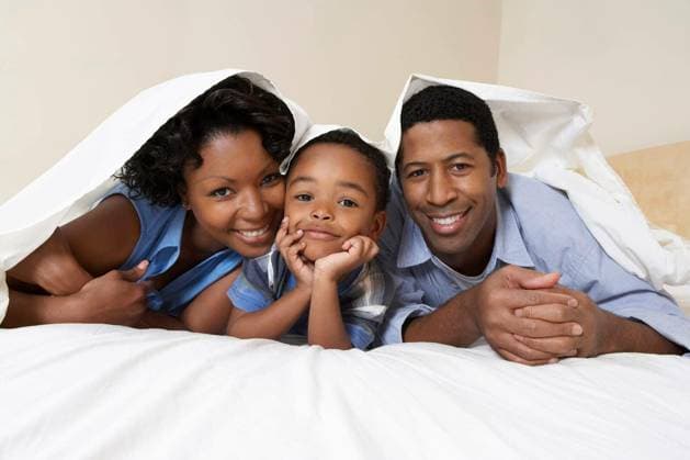 Couple With Son Lying Underneath Sheet - Portrait of an African American couple with son lying underneath sheet model released Symbolfoto Copyright: xmoodboardx Panthermedia75323894.jpg
