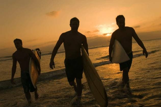 Surfers Carrying Surfboards Out Of Surf At Sunset - Full length of three surfers carrying surfboards out of surf at sunset model released Symbolfoto Copyright: xmoodboardx Panthermedia75338438.jpg
