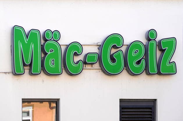 Mäc-Geiz, Firmenlogo, Leuchtreklame an einer Hauswand, deutscher Non-Food-Discounter