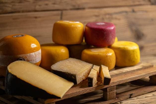 Assortment of artisanal gouda cheese wheels and wedges displayed on a wooden pallet Copyright: xphbcz_1x Panthermedia101077616.jpg