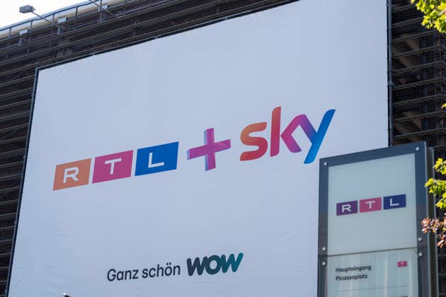 An der Einfahrt zu einem Parkhaus auf dem Gelände von RTL Deutschland hängt ein Plakat mit dem Slogan RTL+ Sky ganz schön WOW. Nach einer wettbewerbsrechtlichen Prüfung hat die EU-Kommission die Übernahme von Sky Deutschland durch die RTL Group genehmigt. RTL Medienunternehmen Firmensitz am Kölner Messeturm. Der Hauptsitz des TV-Sender RTL am Picassoplatz in Köln (Koeln) Deutz. RTL Logo. Copyright: MarcoxBader