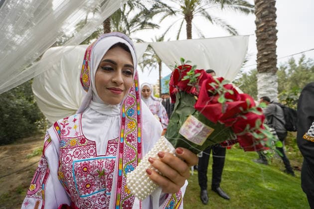 150 couples got married in a mass wedding ceremony in Deir al-Balah DEIR AL-BALAH, GAZA, PALESTINE - APRIL 24: A bride holds a bouquet as mass wedding ceremony organized by the United Arab Emirates under the ‘Al-Fares Al-Shahem’ initiative where 150 Palestinian couples got married in Deir al-Balah, Gaza, Palestine, on April 24, 2026. Adam Bilal Anadolu Deir al-Balah Gaza. Editorial use only. Please get in touch for any other usage.  Copyright: x2026xAnadoluxAdamxBilalx