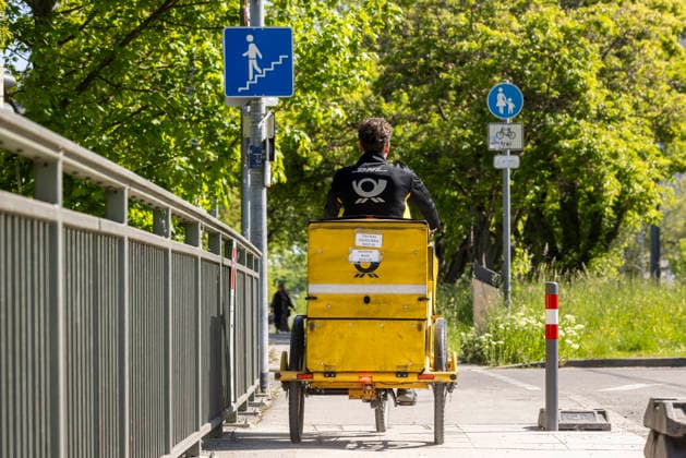 Briefträger unterwegs mit seinem Fahrrad. 29.04.2026, Stuttgart, Baden-Württemberg, Deutschland