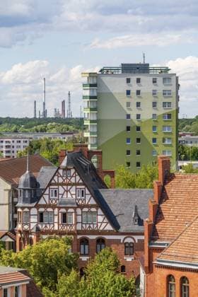 Blick vom Turm der Pfarrkirche St. Katharinen über die historische Stadtmühle im Fachwerkstil und DDR-Plattenbauten zu den Türmen und Schornsteinen der Erdöl-Raffinerie PCK, Schwedt an der Oder, Uckermark, Brandenburg, Deutschland View from the tower of the parish church of St. Katharinen over the historic half-timbered town mill and GDR prefabricated buildings to the towers and chimneys of the PCK oil refinery, Schwedt an der Oder, Uckermark, Brandenburg, Germany Copyright: imageBROKER OliverxGerhard ibxoge17409087