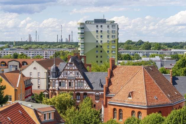 Blick vom Turm der Pfarrkirche St. Katharinen über die historische Stadtmühle im Fachwerkstil und DDR-Plattenbauten zu den Türmen und Schornsteinen der Erdöl-Raffinerie PCK, Schwedt an der Oder, Uckermark, Brandenburg, Deutschland View from the tower of the parish church of St. Katharinen over the historic half-timbered town mill and GDR prefabricated buildings to the towers and chimneys of the PCK oil refinery, Schwedt an der Oder, Uckermark, Brandenburg, Germany Copyright: imageBROKER OliverxGerhard ibxoge17409088