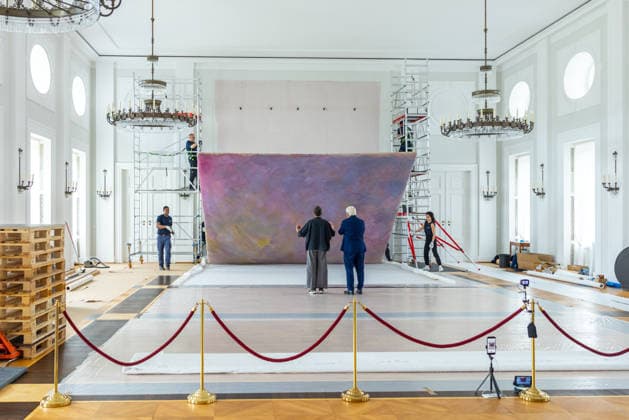 Sanierungsarbeiten im Schloss Bellevue Abbau des Kunstwerks von Künstler Gotthard Graubner im Großen Saal des Schlosses Bellevue. Deutschland, Berlin am 5. Mai 2026: Restauratorin Hana Streicher erläutert Bundespräsident Frank-Walter Steinmeier im großen Festsaal den Abbau des Kunstwerks. Im Zuge der über 600¯Millionen Euro teuren grundlegenden Sanierung des Amtssitzes des deutschen Bundespräsidenten werden an den Wandflächen der beiden Stirnseiten des Großen Saales zwei großformatige Farbraumkörper (Kissenbilder) des Künstlers Gotthard Graubner mit dem Titel Begegnungen (1988) abgehängt.