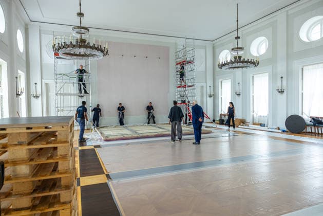 Sanierungsarbeiten im Schloss Bellevue Abbau des Kunstwerks von Künstler Gotthard Graubner im Großen Saal des Schlosses Bellevue. Deutschland, Berlin am 5. Mai 2026: Restauratorin Hana Streicher erläutert Bundespräsident Frank-Walter Steinmeier im großen Festsaal den Abbau des Kunstwerks. Im Zuge der über 600¯Millionen Euro teuren grundlegenden Sanierung des Amtssitzes des deutschen Bundespräsidenten werden an den Wandflächen der beiden Stirnseiten des Großen Saales zwei großformatige Farbraumkörper (Kissenbilder) des Künstlers Gotthard Graubner mit dem Titel Begegnungen (1988) abgehängt.