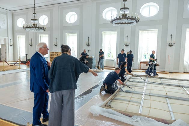 Sanierungsarbeiten im Schloss Bellevue Abbau des Kunstwerks von Künstler Gotthard Graubner im Großen Saal des Schlosses Bellevue. Deutschland, Berlin am 5. Mai 2026: Restauratorin Hana Streicher erläutert Bundespräsident Frank-Walter Steinmeier im großen Festsaal den Abbau des Kunstwerks. Im Zuge der über 600¯Millionen Euro teuren grundlegenden Sanierung des Amtssitzes des deutschen Bundespräsidenten werden an den Wandflächen der beiden Stirnseiten des Großen Saales zwei großformatige Farbraumkörper (Kissenbilder) des Künstlers Gotthard Graubner mit dem Titel Begegnungen (1988) abgehängt.
