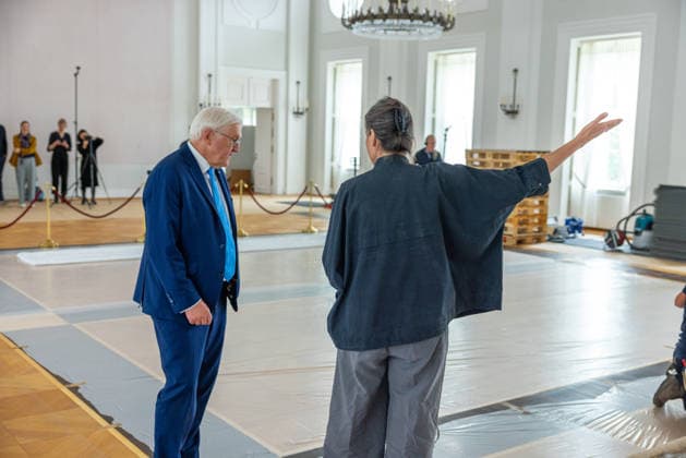 Sanierungsarbeiten im Schloss Bellevue Abbau des Kunstwerks von Künstler Gotthard Graubner im Großen Saal des Schlosses Bellevue. Deutschland, Berlin am 5. Mai 2026: Restauratorin Hana Streicher erläutert Bundespräsident Frank-Walter Steinmeier im großen Festsaal den Abbau des Kunstwerks. Im Zuge der über 600¯Millionen Euro teuren grundlegenden Sanierung des Amtssitzes des deutschen Bundespräsidenten werden an den Wandflächen der beiden Stirnseiten des Großen Saales zwei großformatige Farbraumkörper (Kissenbilder) des Künstlers Gotthard Graubner mit dem Titel Begegnungen (1988) abgehängt.